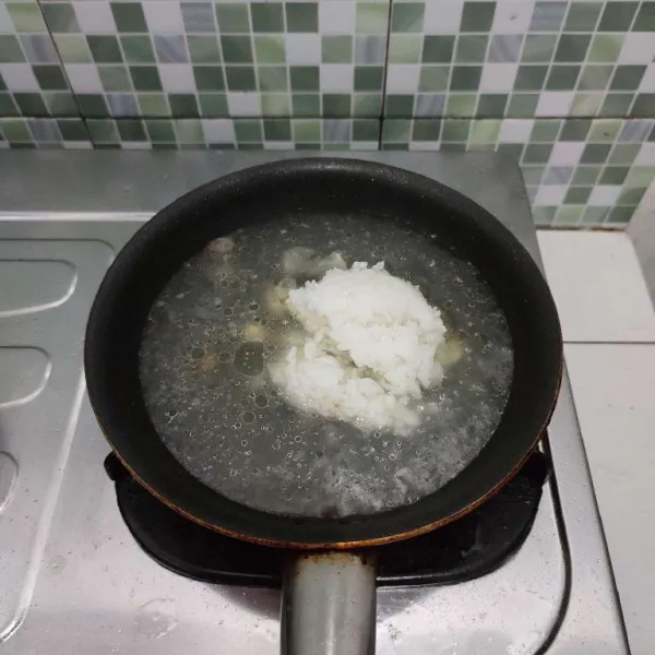 Tambahkan nasi putih, aduk rata. Rebus sebentar hingga nasi mengembang.