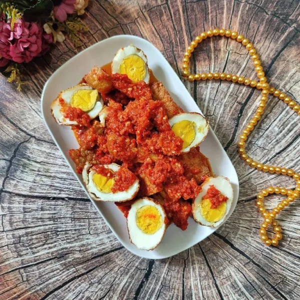 Tata tahu, tempe balado di atas piring saji, kemudian susun telur goreng, dan siram dengan sisa cabe balado. Kemudian sajikan.
