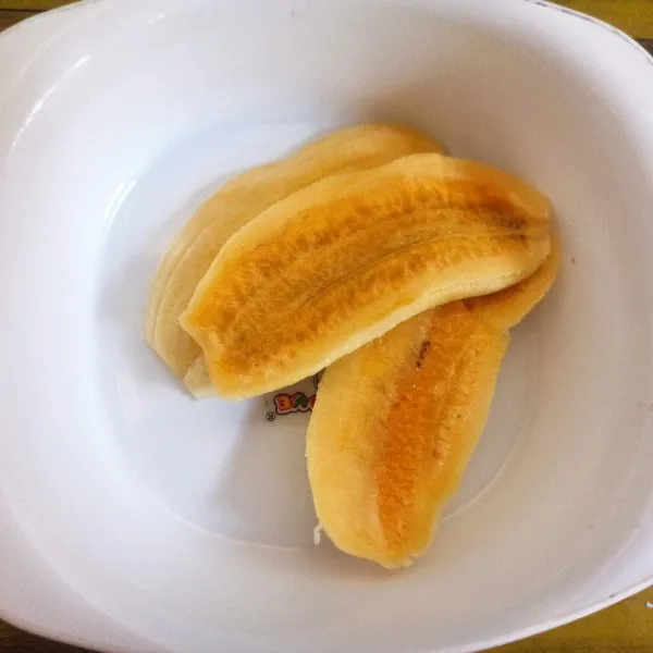 Kupas pisang kemudian belah menjadi 3 bagian.