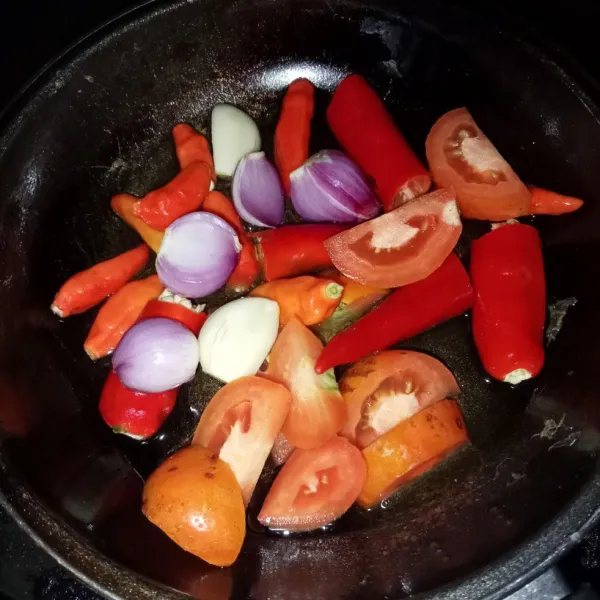 Goreng cabai rawit, cabai merah, tomat, bawang merah dan bawang putih sampai layu.