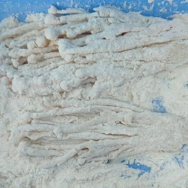 Masukkan kembali ke tepung kering, remas perlahan hingga semua permukaan terbalur tepung.