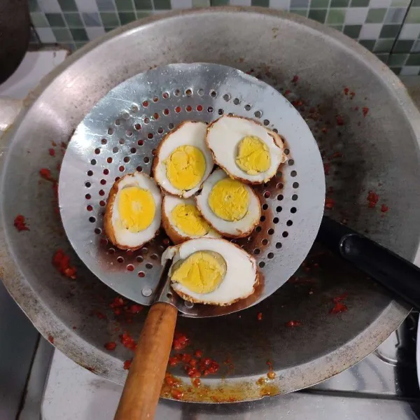 Potong telur menjadi 2 bagian, jika tidak mau dipotong juga tidak masalah.