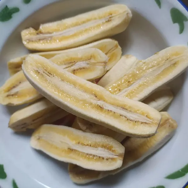 Kupas pisang, kemuadian belah menjadi 2-3 bagian.