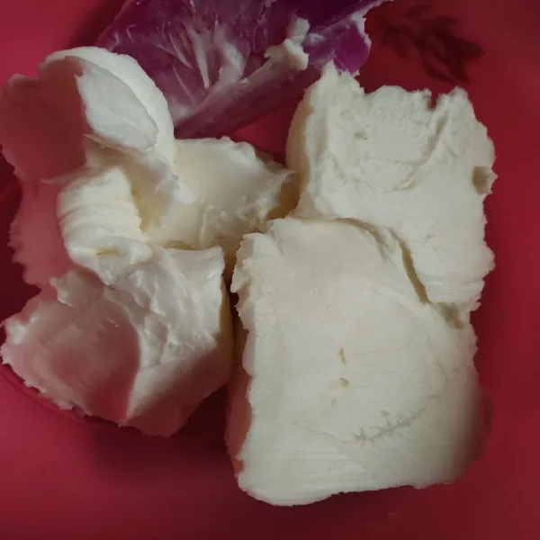 Campur mentega putih dan soft cream dalam wadah.