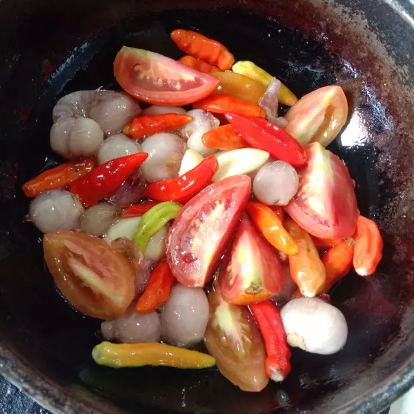 Goreng tomat, bawang merah, bawang putih, dan cabe sampai layu.