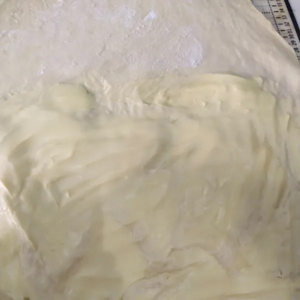Langkah yang pertama, aduk adonan hingga setengah kalis lalu diamkan selama 10 menit lalu setelah 10 menit kemudian olesi dengan mentega pastry kemudian lipat.