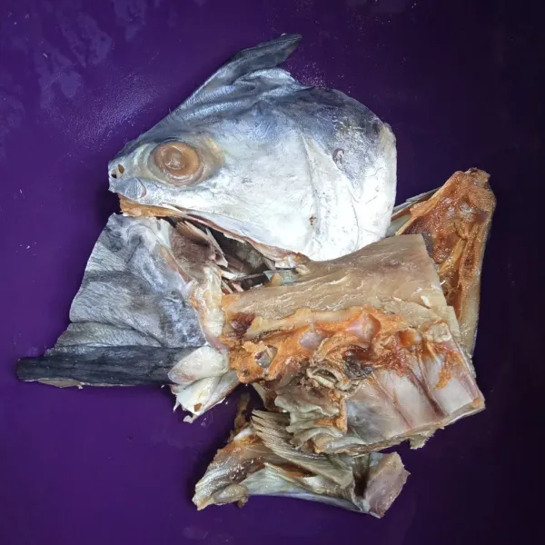 Potong-potong kepala ikan asin dan rendam di air sekitar 30 menit, lalu cuci bersih.