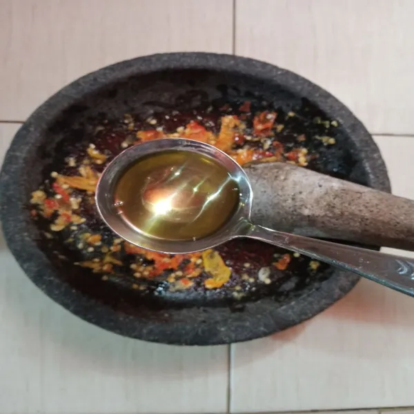Ambil sedikit minyak panas saat menggoreng tahu, guyurkan ke sambal secara merata.