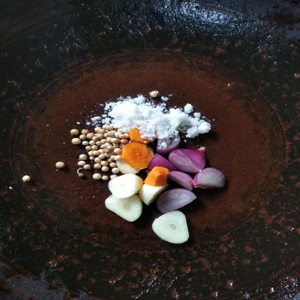 Kupas kunyit, bawang merah dan bawang putih, taruh di cobek bersama garam dan ketumbar.