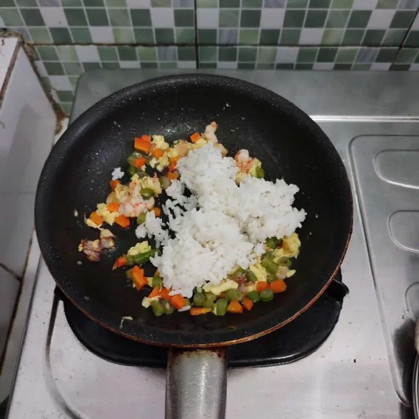Kemudian masukkan nasi putih dan daun bawang, aduk cepat.