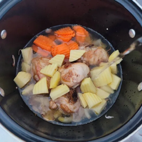 Masukkan potongan wortel, kentang, ayam dan air. Rebus hingga wortel dan kentang empuk.