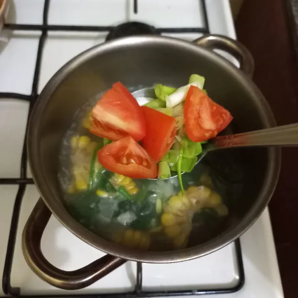 Masukkan irisan tomat dan daun bawang, masak hingga matang.