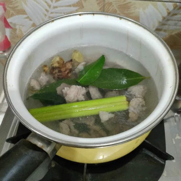 Rebus daging pertama sekitar 3 menit, lalu buang airnya, cuci dagingnya menggunakan air matang. Rebus kembali, beri serai, jahe, lengkuas, daun jeruk dan daun salam. Rebus sampai benar-benar mendidih.