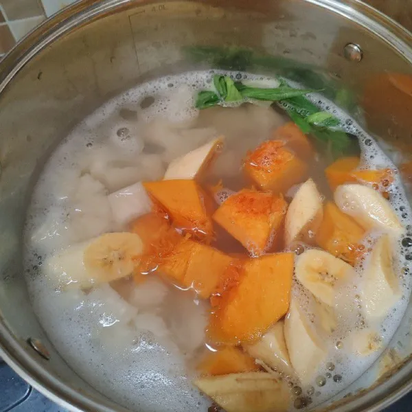 Kemudian masukkan labu dan pisang, aduk rata dan masak hingga labu matang dan empuk.