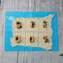 Letakkan pisang di atas kulit puff pastry, lalu tambahkan keju dan coklat meses.