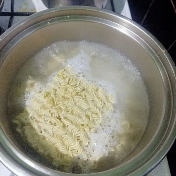 Siapkan panci lalu isikan dengan air. Lalu rebus air dan masukkan mie. Rebus sampai setengah matang.