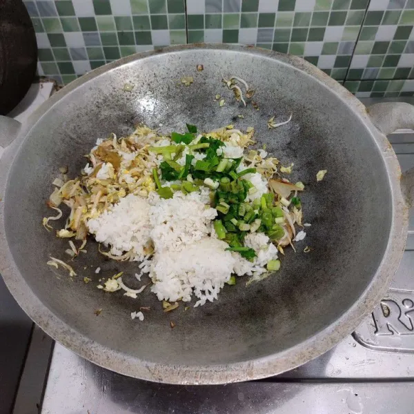 Tambahkan nasi dan daun bawang serta seledri aduk rata.