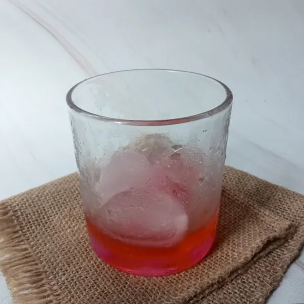 Masukkan sirup cocopandan dan es batu ke dalam gelas.