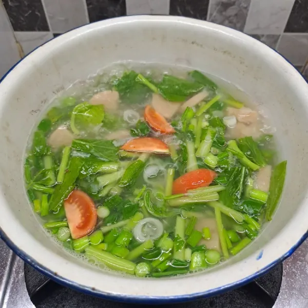 Masukkan irisan bakso, tomat, daun seledri dan daun bawang. Masak sebentar, lalu angkat dan matikan kompor. Ambil mangkok saji, beri sohun secukupnya. Tuang kuah dan isinya. Sajikan.