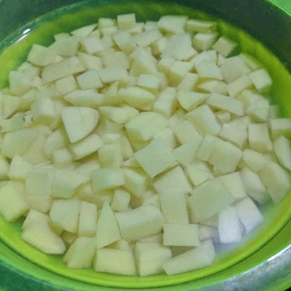 Kupas kentang kemudian potong dadu. Taruh dalam wadah berisi air agar tidak menghitam. Cuci bersih kentang, hingga air cucian bening.
