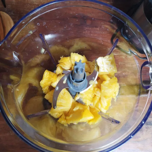 Potong-potong nanas lalu masukkan ke dalam blender.