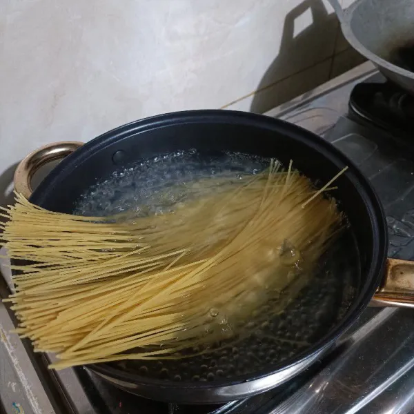 Didihkan air kemudian masukkan pasta spaghetti dan garam.