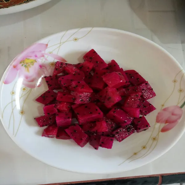 Potong dadu buah naga tata di atas piring.