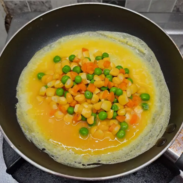 Tambahkan mix vegetables di tengah telur dadar.
