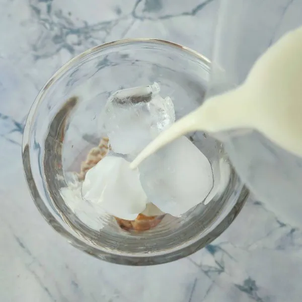 Tuang susu full cream ke dalam gelas.