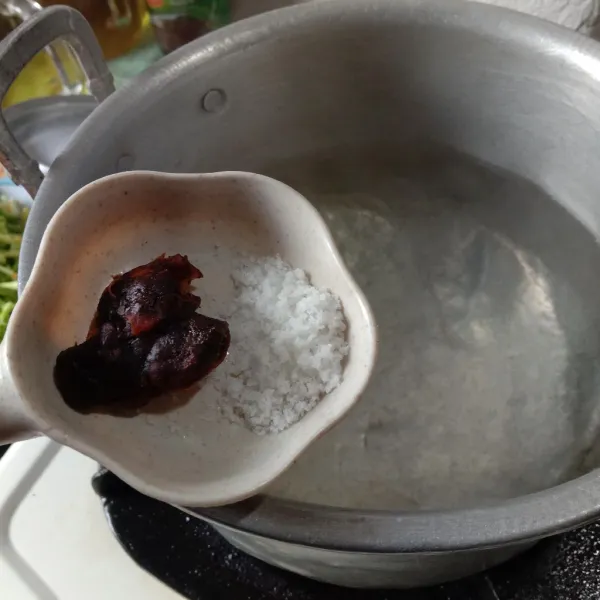 Rebus air dalam panci, biarkan mendidih. Setelah mendidih masukkan asam jawa matang dan garam. Masak sampai asam hancur.