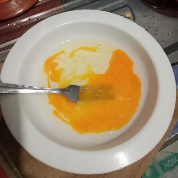 Kocok lepas telur dengan garpu.