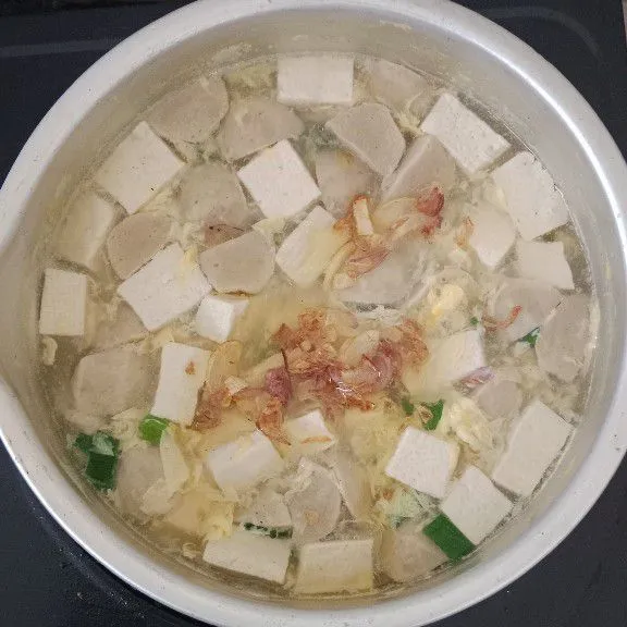 Campurkan tumisan bawang ke dalam panci sup dan di aduk merata, tambahkan daun bawang dan seledri yang telah di potong, garam, lada dan penyedap rasa. Masak sampai mendidih