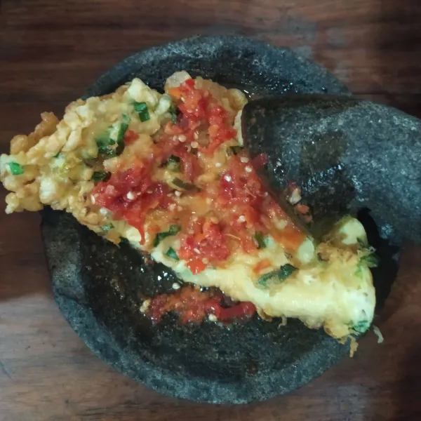 Geprek telur dadar di atas sambal bawang.