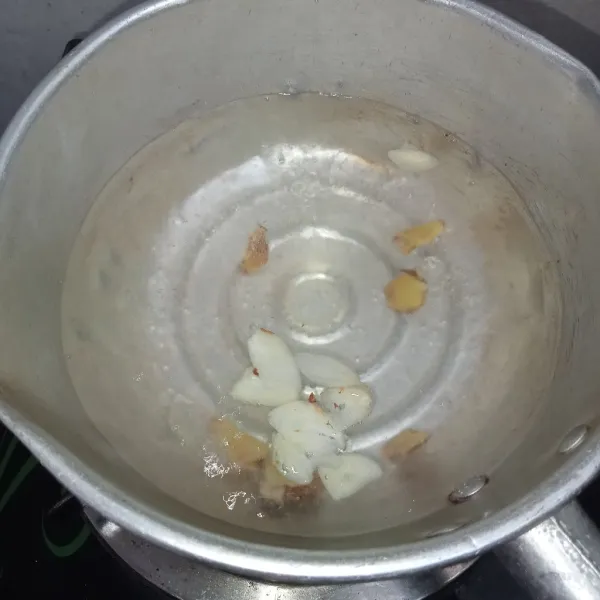 Rebus air hingga mendidih lalu masukkan irisan bawang putih dan temu kunci.