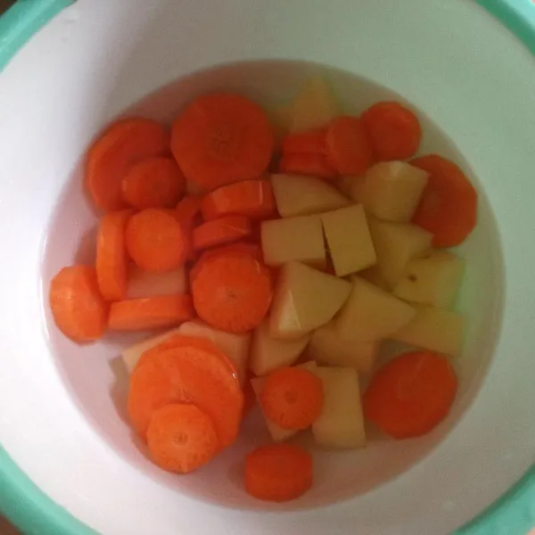 Kupas kentang dan wortel, potong-potong lalu cuci sampai bersih.