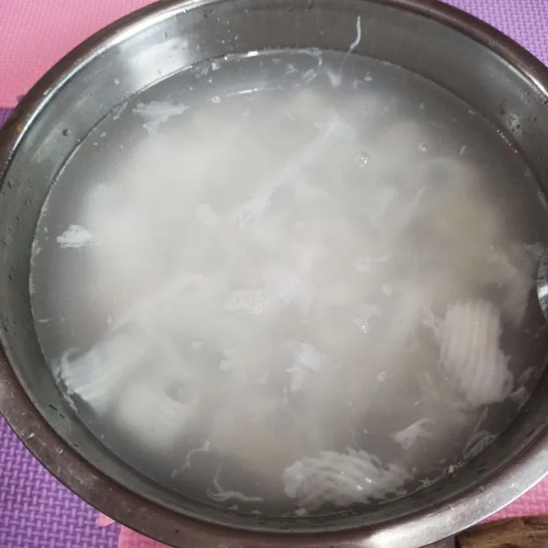 Tuang kelapa muda ke wadah beserta airnya.