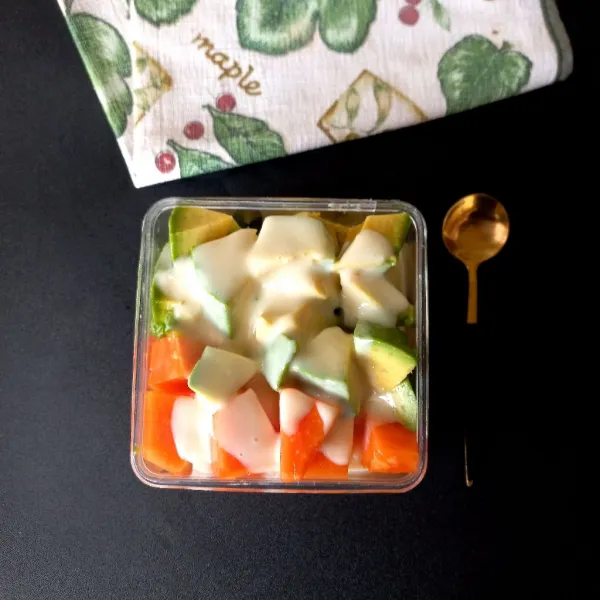 Tuang vla salad buah pada potongan pepaya dan alpukat.
