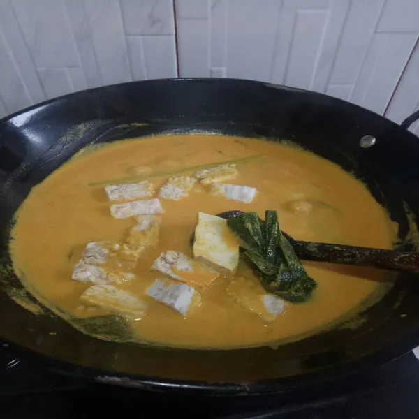 Jika sudah mendidih masukkan tahu dan tempe aduk sesekali dengan api sedang.