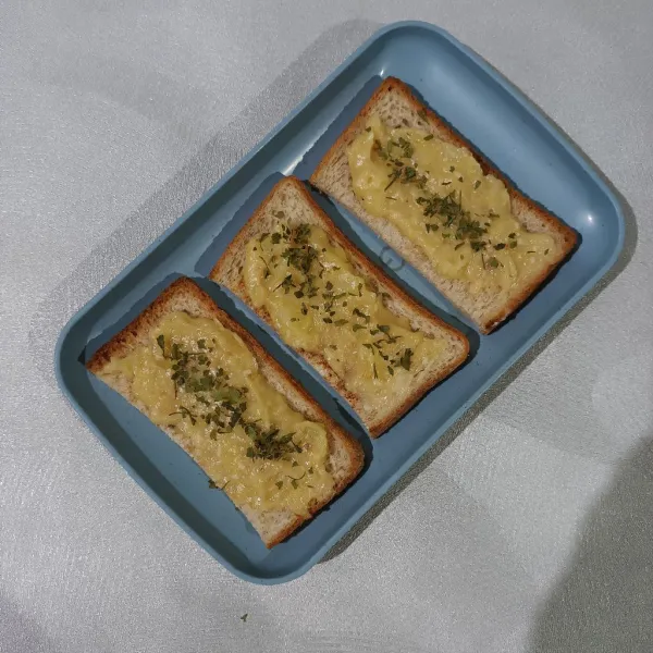 Siapkan roti panggang, lalu olesi dengan mashed potato di atasnya dan taburi daun oregano. Lalu siap disajikan.