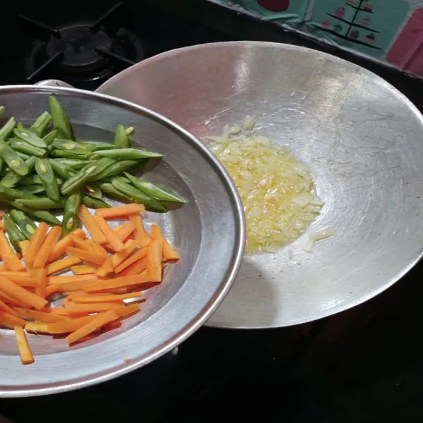 Panaskan minyak dalam wajan, tumis bawang bombay, dan bawang putih hingga harum, kemudian masukkan wortel dan buncis, masak hingga agak layu.