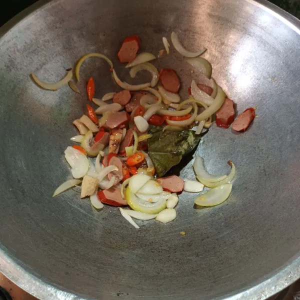 Tumis bawang putih, bawang bombay, cabe, daun salam dan lengkuas sampai harum. Lalu masukkan sosis. Aduk.