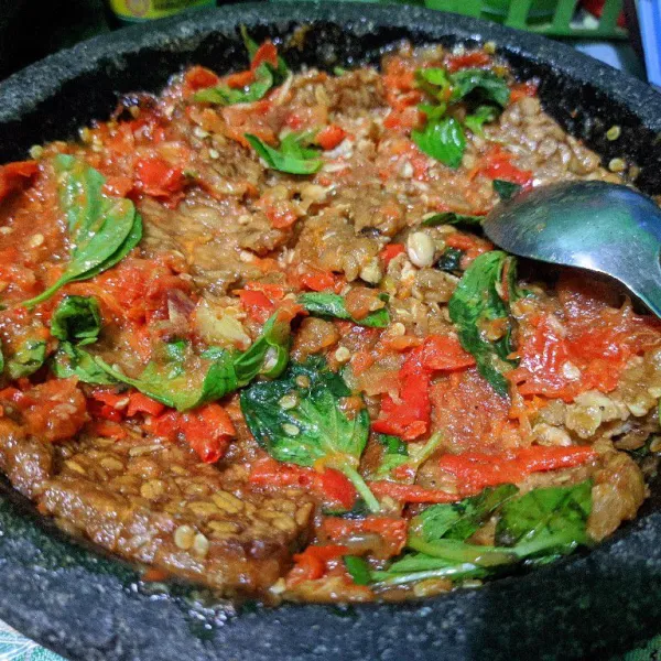 Masukkan kemangi, uleg sebentar kemudian masukkan tempe goreng. Penyet/pecek tempe hingga merata dengan sambal dan kemangi. 💕