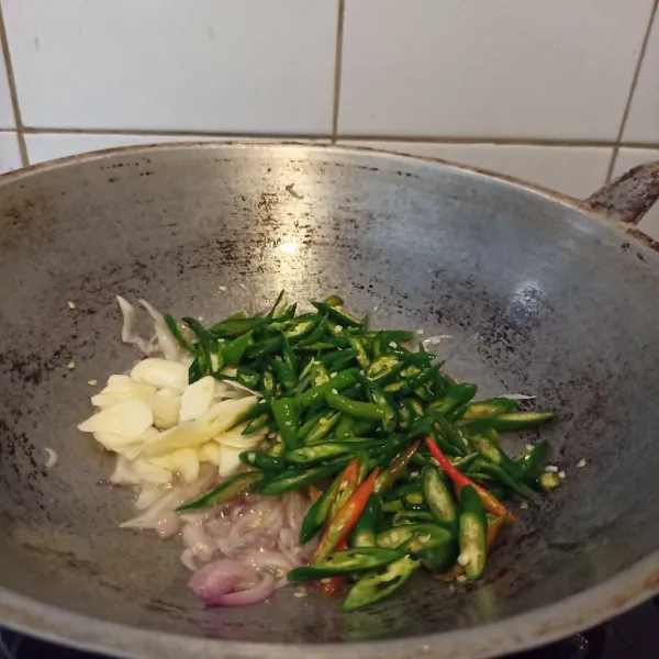 Masukkan bawang putih dan cabai ijo yang sudah di iris. Tumis hingga layu dan harum.