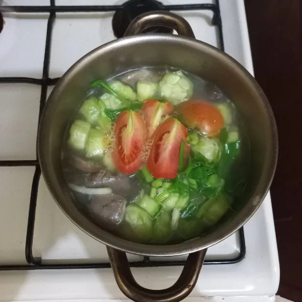 Tambahkan irisan tomat dan daun bawang, masak hingga matang.