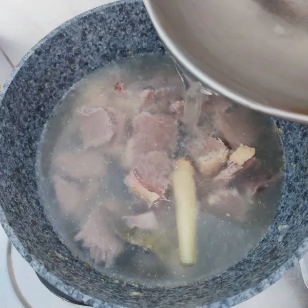 Masukkan daging yang sudah dipotong dan sisa air rebusan, masak sampai mendidih.