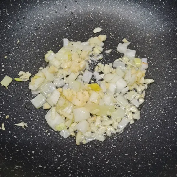 Tumis bawang putih dan bawang bombay dengan sedikit minyak sampai layu dan harum.