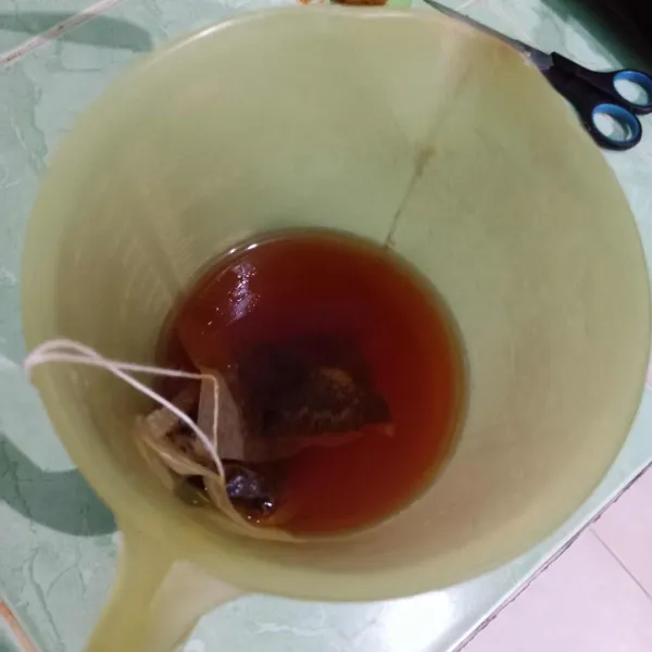 Rendam teh celup dalam air panas hingga merah, beri perasan lemon dan gula pasir, aduk rata.