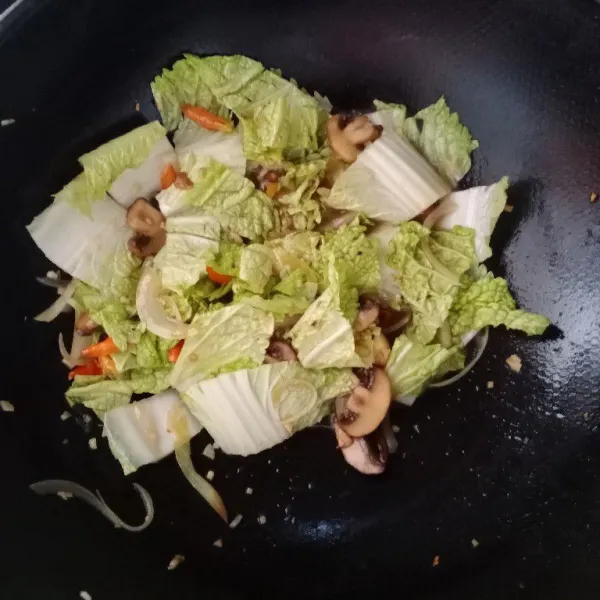 Masukkan air. Lalu masukkan sawi. Aduk dan masak hingga sawi layu.