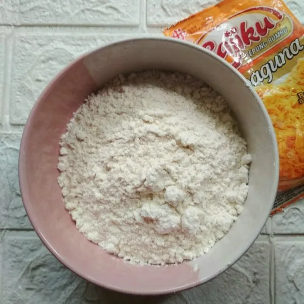 Campur tepung terigu dan tepung serba guna.