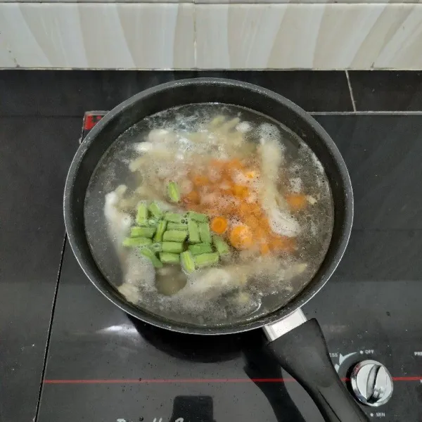 Masukkan wortel, buncis, merica bubuk, dan garam. Aduk rata, masak sebentar hingga sayuran setengah layu.